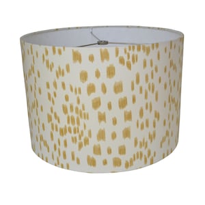 May include: A white lampshade with a gold geometric pattern.