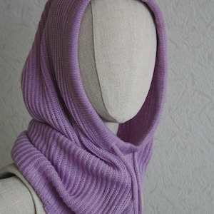 Puede incluir: Un cuello de capucha de punto de color lavanda con cordón. La capucha está hecha de un tejido de punto suave y acanalado.