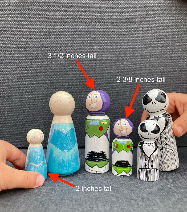 May include: Five wooden peg dolls, hand-painted with different characters. The dolls are 5.1 cm, 6.0 cm, and 8.9 cm tall.