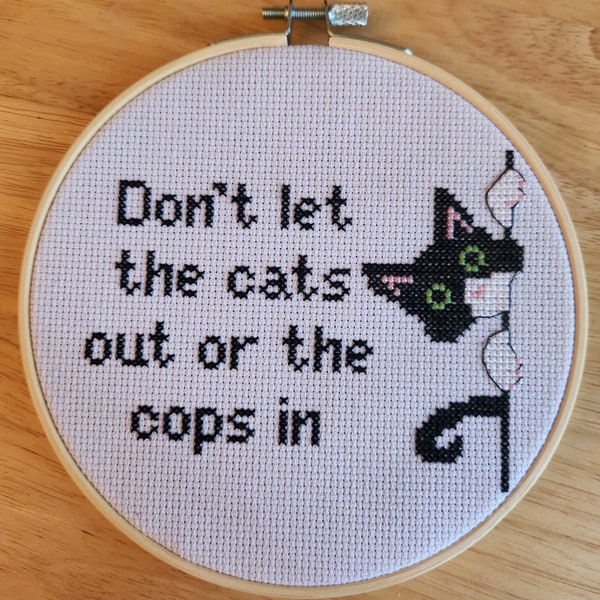 Don't let the cat out or the cops in, finished cross stitch