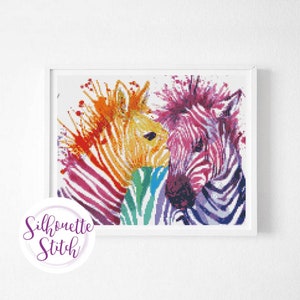 Op de afbeelding: Een kleurrijk schilderij van twee zebra's met regenboogstrepen. De zebra's kijken elkaar aan en lijken te knuffelen. De achtergrond is wit met kleurspatten.