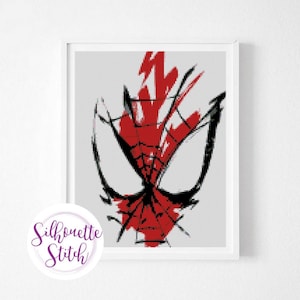 May include: Framed art print featuring a stylized, red and black Spider-Man face design. The artwork has a brushstroke style, with a white background and a white frame. The print includes the text "Silhouette Stitch" in a circular logo.