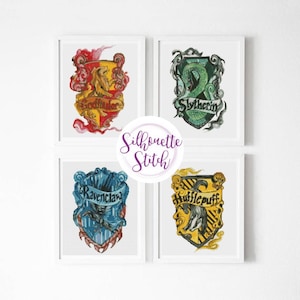 Puede incluir: Cuatro impresiones enmarcadas de los escudos de las casas de Hogwarts. Los escudos son Gryffindor, Slytherin, Ravenclaw y Hufflepuff. Cada escudo está rodeado por un borde blanco y un fondo blanco.