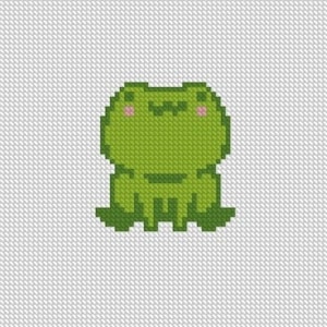 May include: A green pixelated frog with a wide smile and pink cheeks. The frog is sitting on a white background.