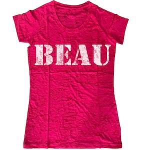 May include: A pink, semi-sheer t-shirt with a white distressed graphic that says "BEAU".