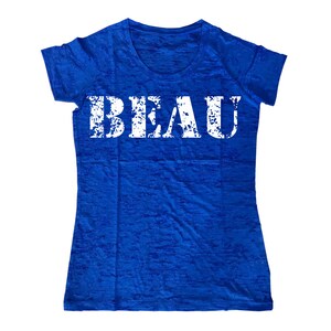 May include: A royal blue t-shirt with a white distressed graphic that says "BEAU".
