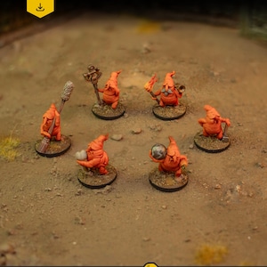 May include: A collection of seven orange miniature fantasy figures, each with unique accessories like a staff, torch, or crystal ball. The figures are set on small, round bases, and the background is a textured, sandy surface. The top left corner has text that says "DIGITAL DOWNLOAD .stl files".