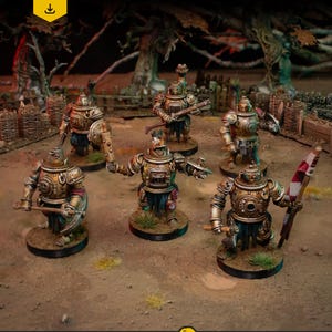 May include: A collection of miniature steampunk-style armored figures, each with distinct weapons and poses. The figures are painted in metallic gold and bronze, with blue and green details. The image includes the text "DIGITAL DOWNLOAD .stl files". The MASSACRO ART & MINIATURES logo is also visible.