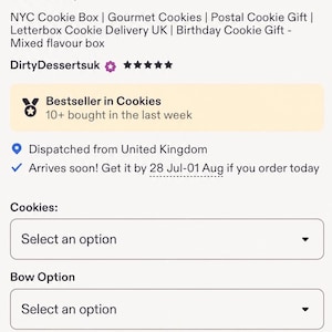 May include: A gift box containing round cookies topped with white icing, colourful sprinkles, and chocolate bar pieces. The cookies are nestled on pink shredded paper inside a rectangular box, presented with an online ordering interface.