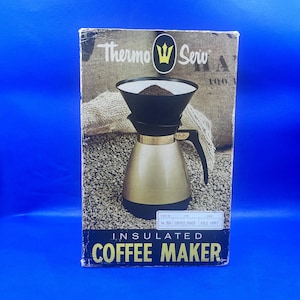 May include: An insulated coffee maker in its original box. The box features the brand name "Thermo Serv" and a gold and black coffee maker. The coffee maker has a black filter holder and a gold-coloured carafe. The box is on a blue background.