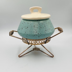 Könnte beinhalten: Ein Set aus drei Keramikbechern mit gesprenkelter, matter Oberfläche. Die Becher sind in Creme-, Hellgrau- und Dunkelgrautönen gehalten. Jeder Becher hat ein schlichtes, minimalistisches Design.