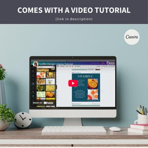 May include: A computer screen showing a Canva design template with a blue background and the text "VITAMIN C". The design features a photo of an orange slice. The screen is on a desk with a keyboard, a clock, and a cup of pens.