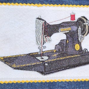 May include: A rectangular fabric patch featuring an embroidered black vintage Singer sewing machine with gold accents and a red thread spool. The design is set on a white background with a yellow scalloped border, stitched onto blue denim fabric.