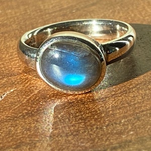 May include: A silver ring with a round, blue labradorite gemstone.