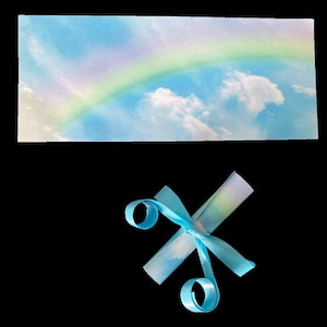 K&ouml;nnte beinhalten: Ein blaues Band, das zu einer Schleife gebunden ist, mit einem hellblauen und wei&szlig;en Hintergrund mit einem Regenbogen.