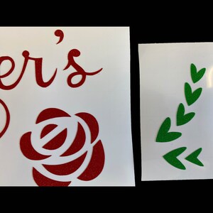 Peut inclure: Deux autocollants en vinyle, l'un avec le mot "er's" en lettres cursives rouges et une rose rouge paillet&eacute;e, et l'autre avec une branche feuillue paillet&eacute;e verte.