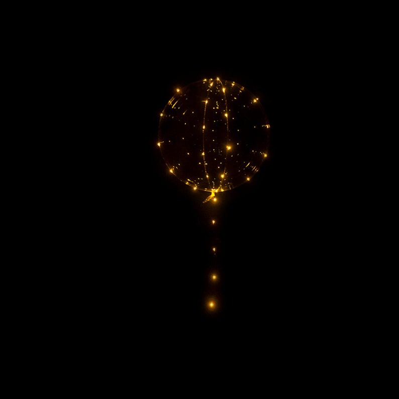 Puede incluir: Un globo transparente con una cadena de luces LED blancas c&aacute;lidas en su interior. El globo est&aacute; inflado y las luces est&aacute;n encendidas, creando un brillo c&aacute;lido.