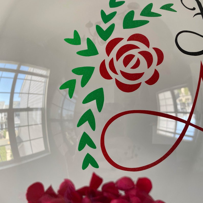 Peut inclure: Un ballon blanc avec une rose rouge et des feuilles vertes, un symbole d'infini rouge et le mot "Love" en &eacute;criture noire.
