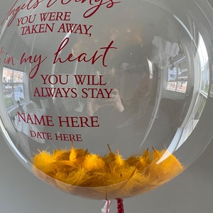 K&ouml;nnte beinhalten: Ein transparenter Ballon, gef&uuml;llt mit gelben Federn und einem roten Band. Auf dem Ballon steht eine Botschaft: "Du wurdest weggenommen, in meinem Herzen. Du wirst immer bleiben. Name hier. Datum hier."