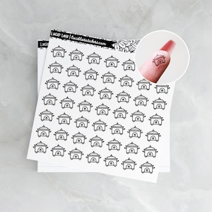 May include: A white ceramic mug with a black handle and the text "But First, Coffee" in a bold, black font. The mug is filled with a dark liquid, likely coffee, and sits on a light-colored surface.