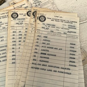 May include: A stack of vintage train line-up reports for foremen and track car operators. The reports are printed on white paper with black ink and include the date 9-19-73, the station "Glenwood", and approximate times for various train locations.