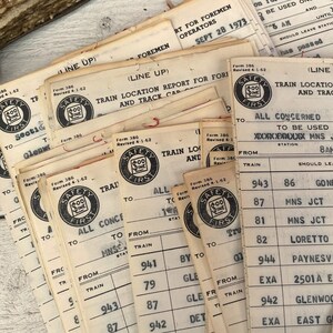 May include: A stack of vintage train safety forms with the text "Safety First" and a dollar sign logo. The forms are printed on white paper and have black ink. The forms are dated September 28, 1973.