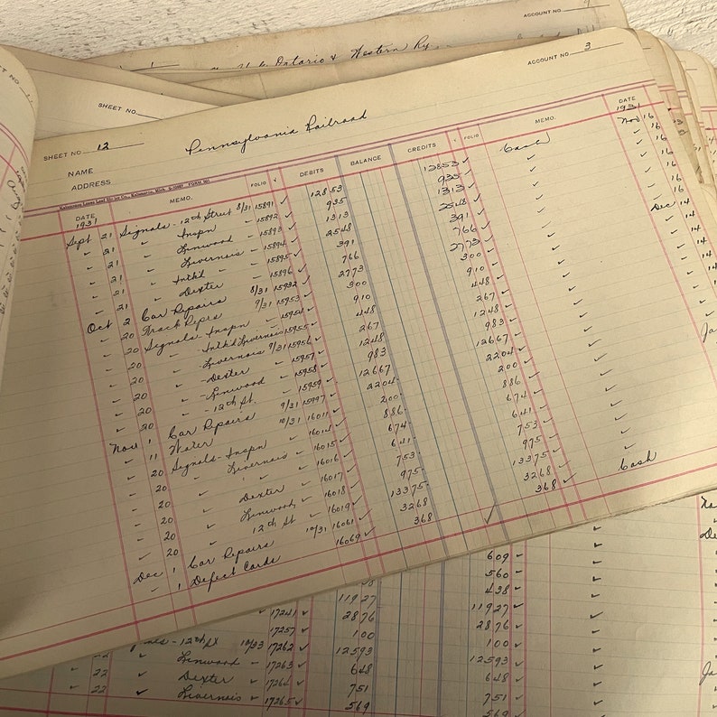 May include: A vintage ledger page with handwritten entries for the Pennsylvania Railroad. The page includes dates, debits, credits, and a balance column. The entries are for various expenses, including car repairs, signals, and track maintenance.