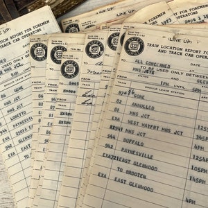 May include: A stack of vintage train location report forms for foremen and track car operators. The forms are printed on white paper with black ink and have a "Safety First" logo. The forms are dated September 1, 1973 and September 14, 1973. The forms list train numbers, locations, and times.