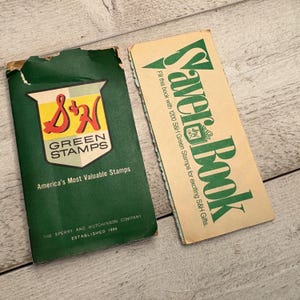 May include: Two vintage green and yellow S&H Green Stamps Saver Books. The front cover of the smaller book says "S&H Green Stamps" and "America's Most Valuable Stamps". The back cover says "The Sperry and Hutchinson Company Established 1896". The larger book says "Saver Book" and "Fill this book with 1200 S&H Green Stamps for exciting S&H Gifts."