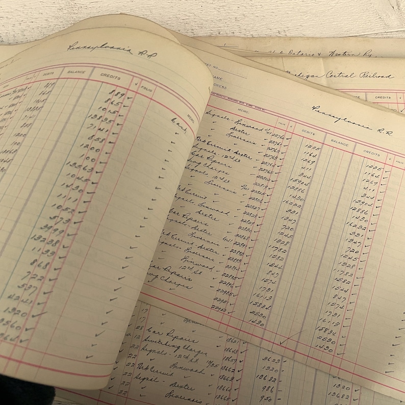 May include: A close-up of a ledger page with handwritten entries for a railroad company. The page shows the date, debits, credits, and balance for each transaction. The ledger is dated 1904.