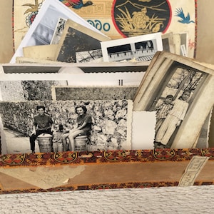 Könnte beinhalten: Eine dekorative Box, überfüllt mit einer Sammlung von Vintage-Schwarzweißfotografien. Die Box hat ein gemustertes Äußeres mit roten, orangefarbenen und braunen Akzenten. Die Fotografien zeigen Menschen und Szenen und bieten einen Einblick in die Vergangenheit.