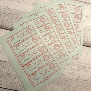 Könnte beinhalten: Ein Stapel grüner Papiertickets mit rotem Text. Die Tickets sind für ein Kino und haben den Text "KIHO" und "150484" aufgedruckt. Die Tickets sind für 70 Kopecks.