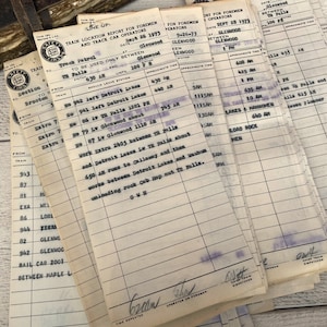 May include: A stack of vintage train location report forms for foremen and track car operators. The forms are dated September 26, 1973, and list train numbers, locations, and approximate times. The forms are printed on white paper with blue ink.