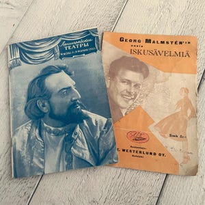 May include: Two vintage paperbacks, one blue with a portrait of a man with a beard and the text "Ленинградские ТЕАТРЫ" and the other orange with a portrait of a man and the text "GEORG MALMSTEN'I uusia ISKUSÄVELMIÄ"