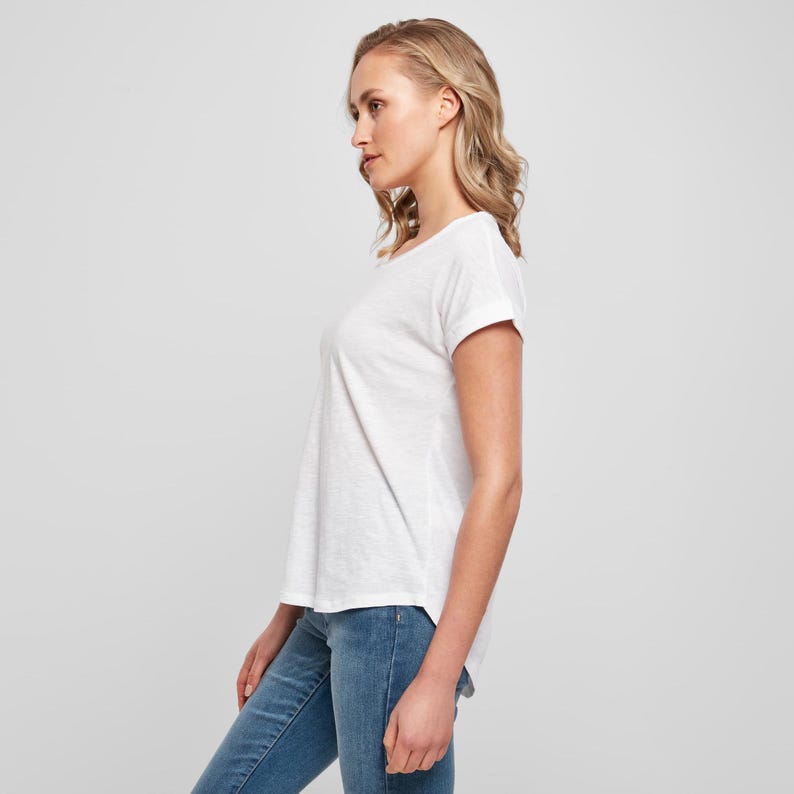 Side profile of model wearing the white scoop neck t shirt highlighting the relaxed silhouette and lightweight cotton fabric.