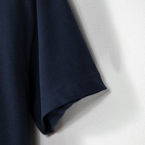 May include: A navy blue short-sleeved t-shirt with a plain design. The t-shirt is made of a soft, comfortable fabric.