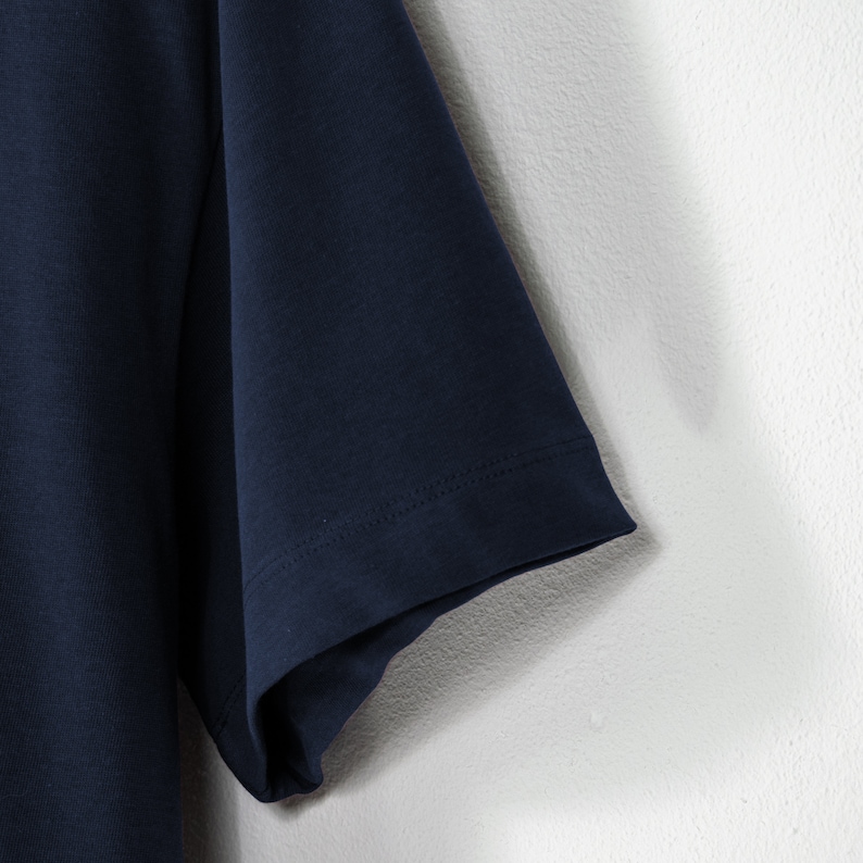 May include: A navy blue short-sleeved t-shirt with a plain design. The t-shirt is made of a soft, comfortable fabric.