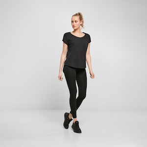 Woman wearing black relaxed fit t shirt with leggings and trainers, casual minimal outfit with loose silhouette and comfortable everyday styling