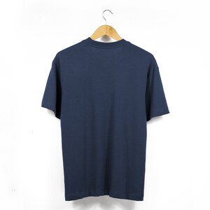May include: A plain navy blue t-shirt hanging on a wooden hanger against a white background.