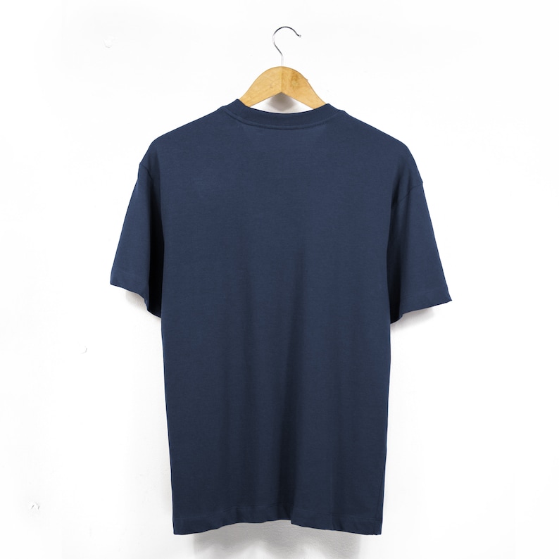 May include: A plain navy blue t-shirt hanging on a wooden hanger against a white background.