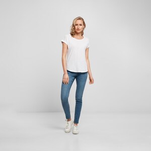 Full body view of model wearing Stevie Nicks vintage rock t shirt with jeans and trainers, casual retro outfit style.