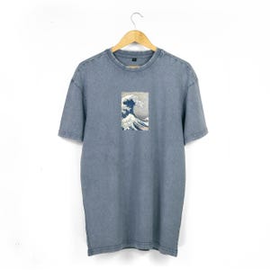 Può includere: Una t-shirt blu con lavaggio vintage con una stampa grafica di La Grande Onda di Kanagawa di Katsushika Hokusai.