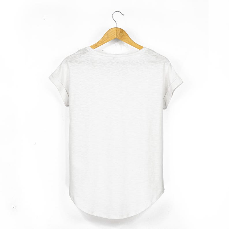 Back view of the white women's scoop neck t shirt showing the relaxed silhouette, rolled sleeves and gently curved hemline.
