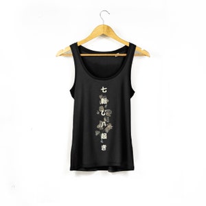 May include: Black tank top with a vertical floral design and Japanese text that reads "七転び八起き" which translates to "fall down seven times, get up eight".