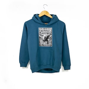 May include: A teal blue hoodie featuring a black and white graphic print of a Godzilla poster. The poster includes the text "The Return of Godzilla" and Japanese text.
