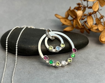 Birthstone family necklace with up to 15 birthstones set on a 1" sterling silver circle and a smaller inner circle