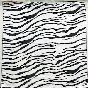 May include: Black and white zebra print bandana. The bandana has a white background with black stripes.
