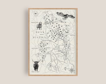 Puede incluir: Una impresión en blanco y negro enmarcada del mapa del Peak District, con ilustraciones de una oveja, un búho y una vaca de las Highlands. El mapa incluye nombres de lugares y una rosa de los vientos, todo dentro de un marco de madera clara.