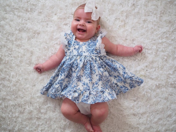 Robe bébé fille bleue imprimée de petites fleurs jaunes et blanches