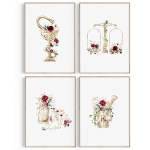 Puede incluir: Conjunto de cuatro impresiones enmarcadas en dorado y blanco con dise&ntilde;os florales de acuarela y s&iacute;mbolos de botica. Los s&iacute;mbolos incluyen una serpiente enroscada alrededor de una copa, una balanza, un frasco y un mortero y un pil&oacute;n.